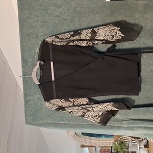 Black Wrap Top with White Design On The Sleeves.